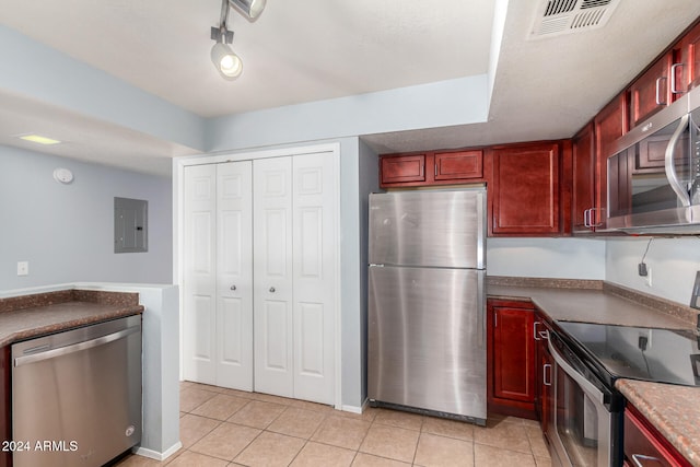 kitchen with electric panel, light tile patterned flooring, and stainless steel appliances