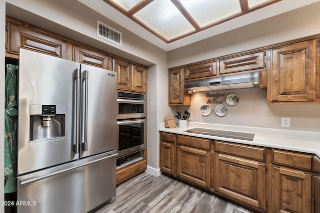 5130 E Superstition Blvd, Apache Junction, AZ 85119 - kitchen featuring appliances with stainless steel finishes, under cabinet range hood, light countertops, light wood-style flooring, and brown cabinets