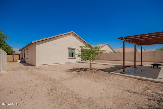 7324 S 254th Dr, Buckeye, AZ 85326 - back of property with a pergola, a patio area, a fenced backyard, stucco siding, and a tiled roof