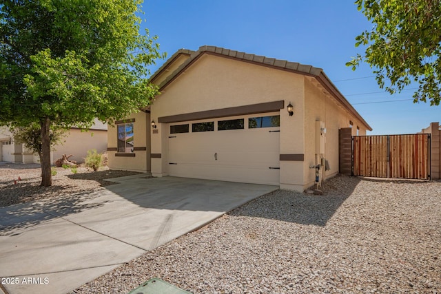 7324 S 254th Dr, Buckeye, AZ 85326 - view of front facade with stucco siding, an attached garage, driveway, and a gate