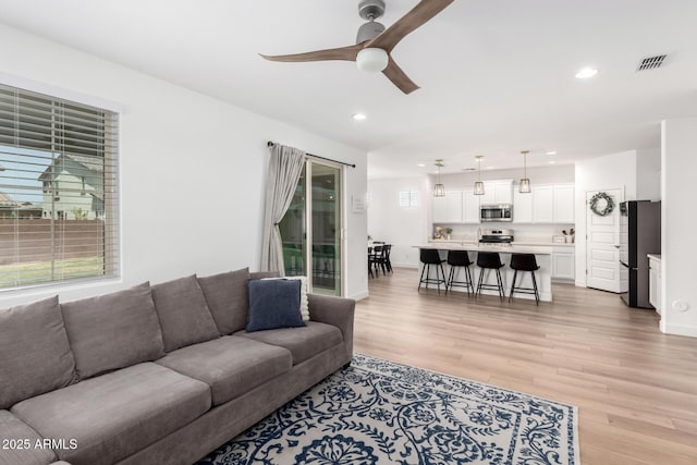 10956 E Thunderbolt Ave, Mesa, AZ 85212 - living room featuring a ceiling fan, recessed lighting, light wood-style flooring, plenty of natural light, and baseboards