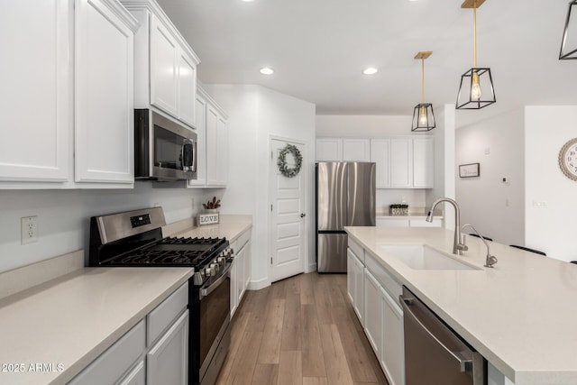 10956 E Thunderbolt Ave, Mesa, AZ 85212 - kitchen featuring stainless steel appliances, a sink, light wood-style flooring, white cabinetry, and an island with sink