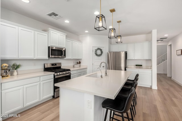10956 E Thunderbolt Ave, Mesa, AZ 85212 - kitchen featuring stainless steel appliances, a sink, recessed lighting, a kitchen bar, and white cabinetry
