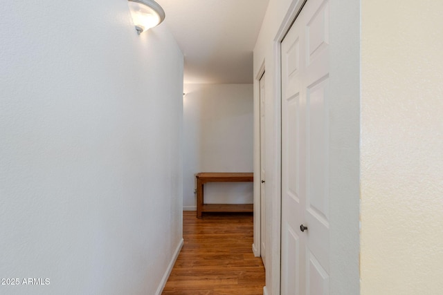 hall featuring baseboards and wood finished floors