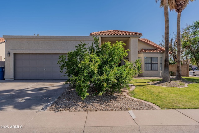 mediterranean / spanish-style home featuring an attached garage, stucco siding, a front yard, a tiled roof, and driveway
