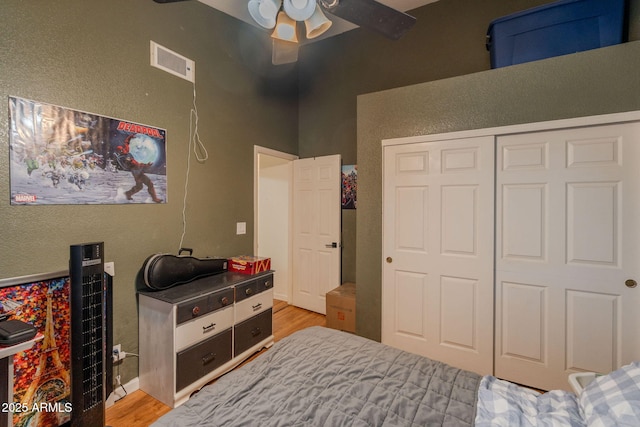 bedroom with visible vents, a ceiling fan, light wood finished floors, and a closet