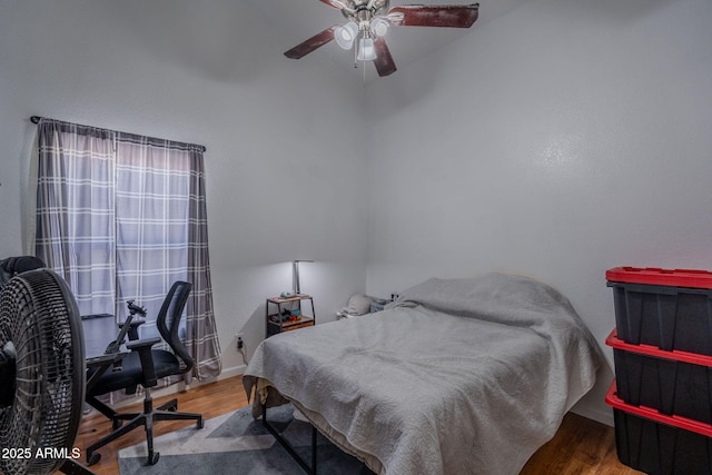 bedroom featuring baseboards, ceiling fan, and wood finished floors