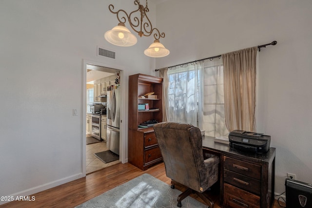 office area with baseboards, visible vents, and light wood-style floors