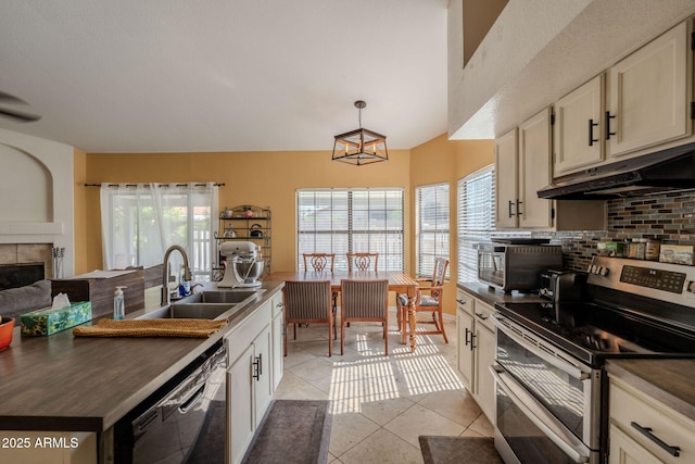 kitchen featuring black dishwasher, dark countertops, double oven range, and a sink