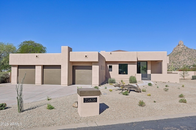 pueblo revival-style home featuring a garage and a mountain view