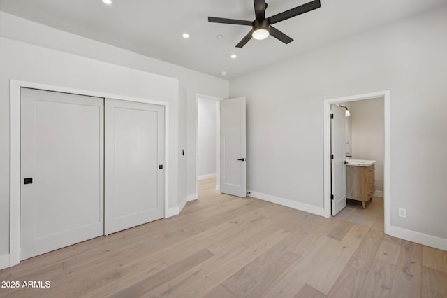 unfurnished bedroom featuring ceiling fan, light wood-type flooring, a closet, and ensuite bath