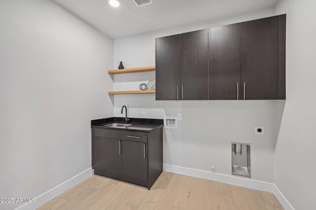 clothes washing area with sink, electric dryer hookup, cabinets, gas dryer hookup, and washer hookup