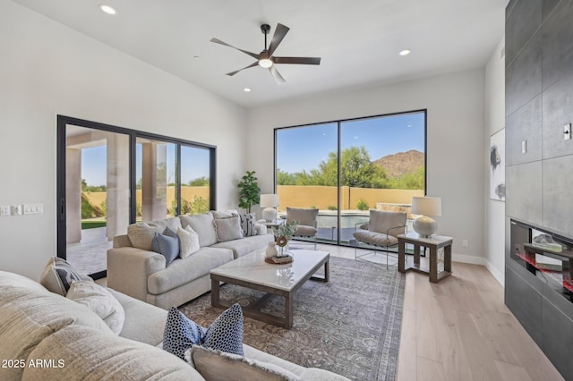 living room featuring light wood-type flooring and ceiling fan