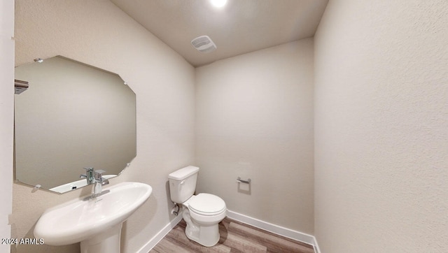 bathroom featuring wood-type flooring, sink, and toilet