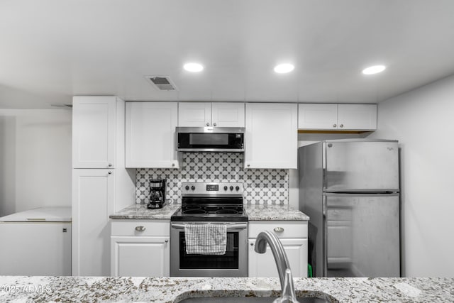 1032 E Redfield Rd, Tempe, AZ 85283 - kitchen featuring stainless steel appliances, white cabinets, decorative backsplash, light stone counters, and recessed lighting