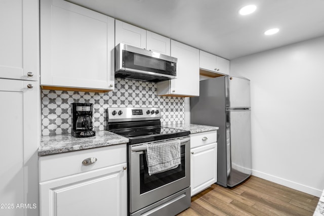 1032 E Redfield Rd, Tempe, AZ 85283 - kitchen with stainless steel appliances, backsplash, white cabinets, light wood finished floors, and recessed lighting
