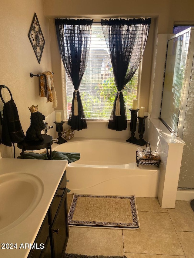 bathroom featuring tile patterned floors, vanity, and shower with separate bathtub