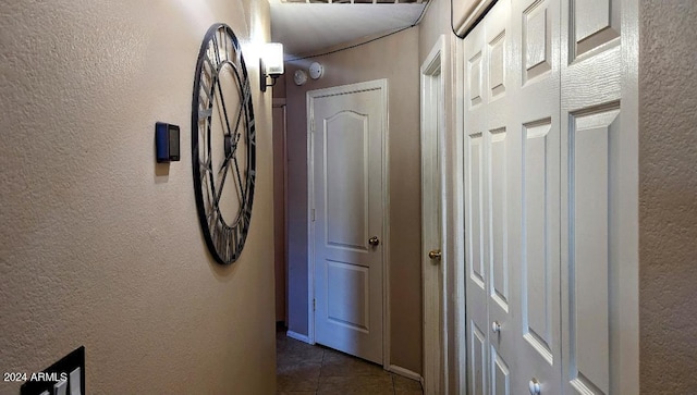 hall featuring dark tile patterned floors