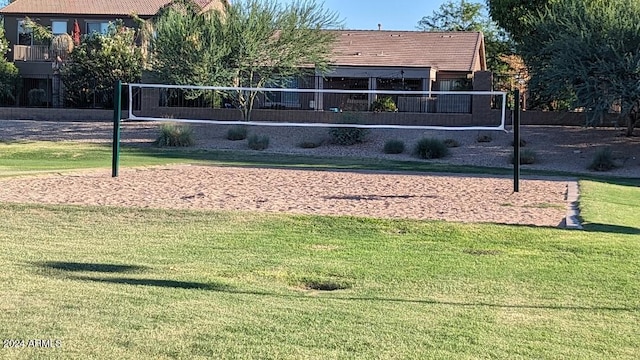 view of home's community with volleyball court and a lawn