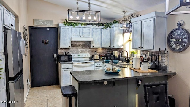 kitchen featuring kitchen peninsula, electric range, sink, hanging light fixtures, and stainless steel fridge