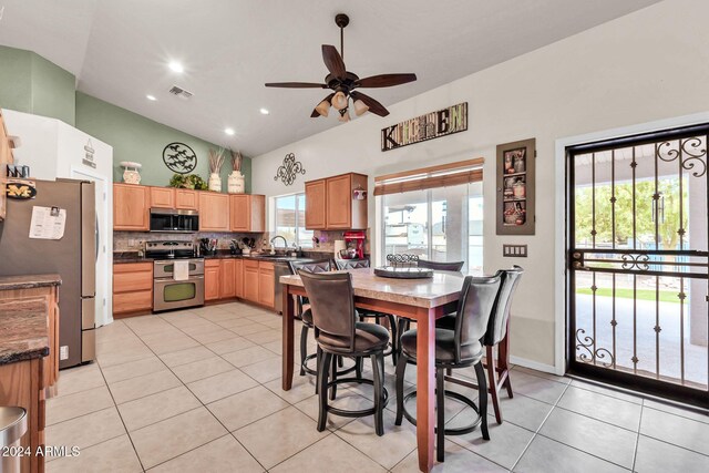 kitchen featuring decorative backsplash, sink, ceiling fan, light tile patterned flooring, and appliances with stainless steel finishes