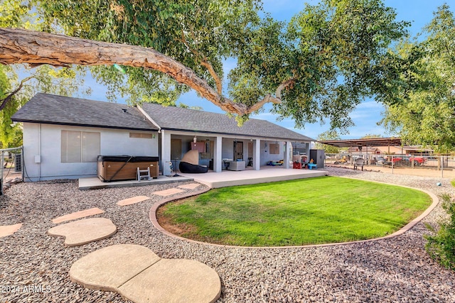 rear view of house with a yard, cooling unit, a hot tub, and a patio area