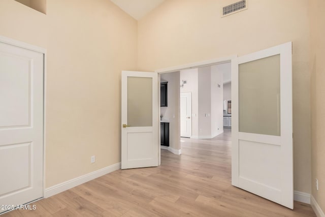 interior space featuring a high ceiling and light wood-type flooring