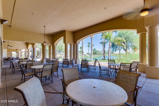 view of patio with ceiling fan and a water view