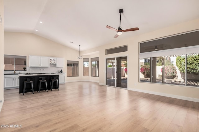 unfurnished living room featuring ceiling fan, high vaulted ceiling, and light hardwood / wood-style flooring