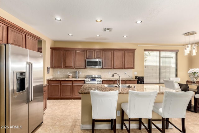 18171 W Marshall Ln, Surprise, AZ 85388 - kitchen featuring a kitchen breakfast bar, visible vents, a center island with sink, a sink, and stainless steel appliances