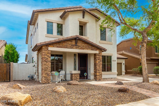 18171 W Marshall Ln, Surprise, AZ 85388 - view of front of house featuring a porch, a garage, fence, stone siding, and stucco siding