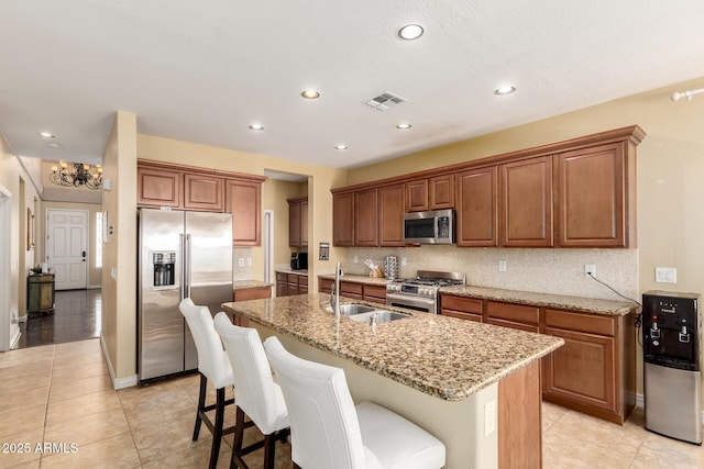 18171 W Marshall Ln, Surprise, AZ 85388 - kitchen featuring visible vents, light tile patterned flooring, a center island with sink, a sink, and appliances with stainless steel finishes