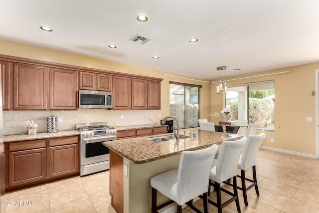 18171 W Marshall Ln, Surprise, AZ 85388 - kitchen with light tile patterned flooring, a sink, brown cabinetry, stainless steel appliances, and visible vents
