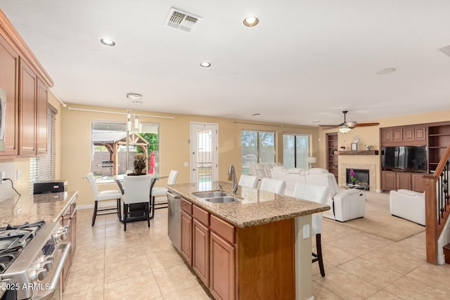18171 W Marshall Ln, Surprise, AZ 85388 - kitchen featuring a breakfast bar area, visible vents, a sink, light tile patterned floors, and stainless steel appliances