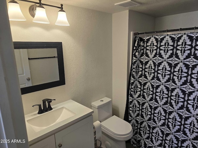 bathroom with toilet, a textured ceiling, a shower with curtain, and vanity