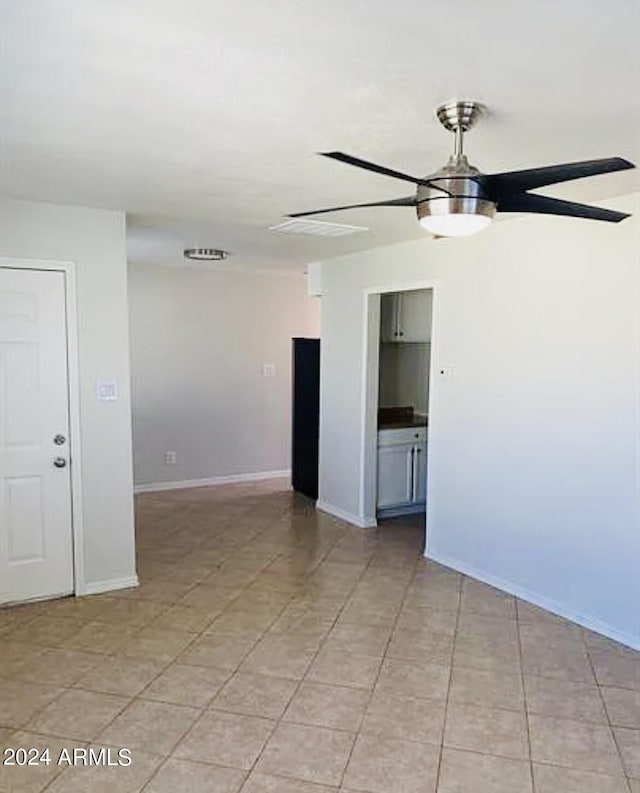 unfurnished room featuring a ceiling fan and baseboards