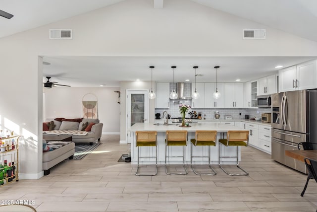 kitchen with stainless steel appliances, light countertops, visible vents, and wall chimney exhaust hood