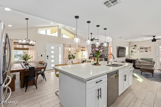 kitchen featuring a sink, visible vents, open floor plan, appliances with stainless steel finishes, and wood tiled floor