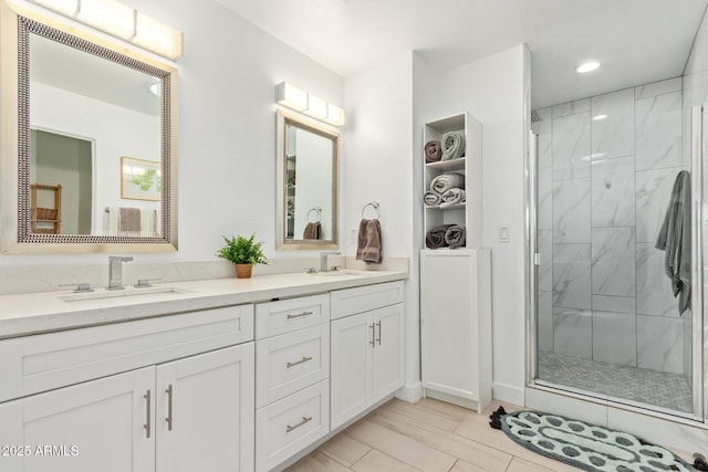 bathroom with a stall shower, a sink, recessed lighting, and double vanity