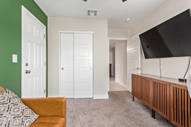 living area with light carpet, visible vents, and baseboards