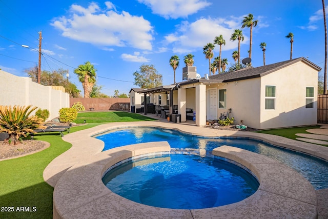 view of swimming pool featuring a pool with connected hot tub, a fenced backyard, and a patio