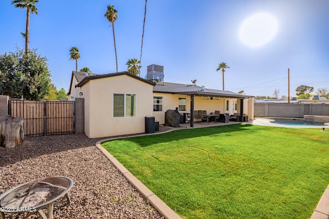 back of property with a yard, stucco siding, a ceiling fan, a patio area, and a fenced backyard