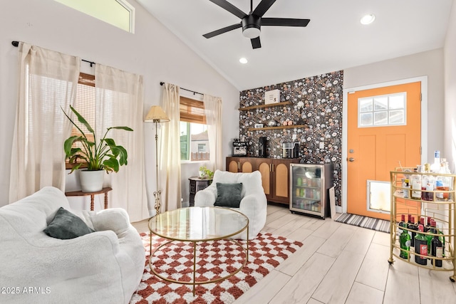 living area with wood finish floors, lofted ceiling, recessed lighting, a ceiling fan, and a bar