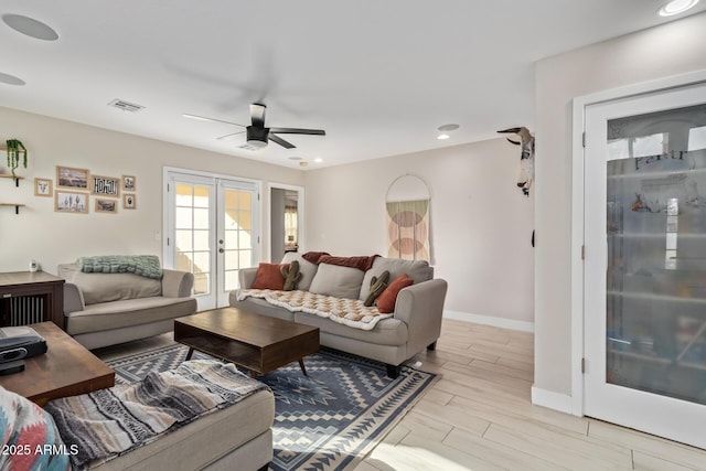 living room with french doors, visible vents, light wood-style flooring, a ceiling fan, and baseboards