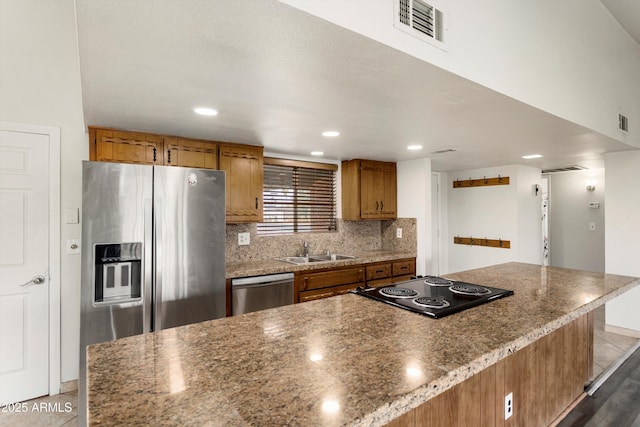 kitchen with visible vents, brown cabinets, stainless steel appliances, and a sink