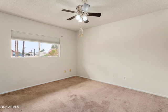 carpeted spare room with baseboards, a textured ceiling, and a ceiling fan