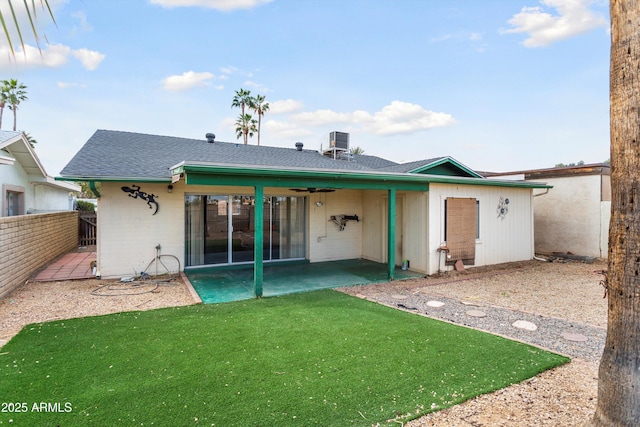 rear view of house with fence, a shingled roof, concrete block siding, ceiling fan, and a patio area