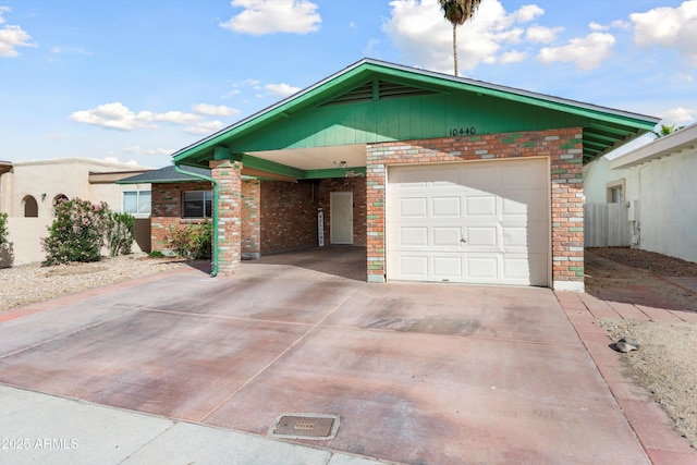 ranch-style house with an attached carport, concrete driveway, an attached garage, and brick siding