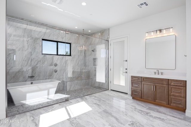 bathroom featuring vanity and independent shower and bath