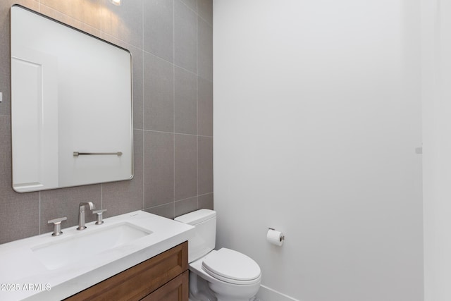 bathroom with tasteful backsplash, vanity, tile walls, and toilet